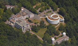 Luftaufnahme Max-Planck-Institut für Astronomie (MPIA) und Haus der Astronomie (HdA) auf dem Heidelberger Königstuhl: Unten rechts die Kuppeln des Elsässer-Labors (MPIA), darüber das galaxienförmige HdA-Gebäude und links davon das MPIA-Hauptgebäude. Bild: Sebastian Egner
