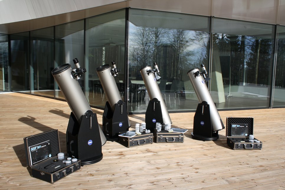 Vier Dobson-teleskope mit Zubehörkoffern auf der Terrasse des Haueses der Astronomie