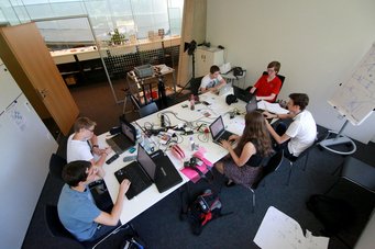 Teilnehmer des Internationalen Sommerpraktikums 2013 Eine Gruppe von sechs älteren Schülerinnen und Schülern arbeiten an einem Konferenztisch im Besprechungszimmer des HdA an Laptops