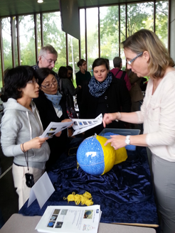 Natalie Fischer stellt während der Ausstellung für Lehrmaterialien beim UNAWE Workshop 2015 das Modell der Sonne vor, in die 1 Million Erden passen.