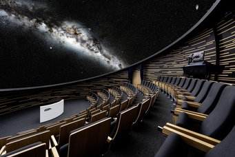 Ein Blick ins All aus dem Haus der Astronomie. Sitzreihen im Inneren des Auditoriums im Haus der Astronomie