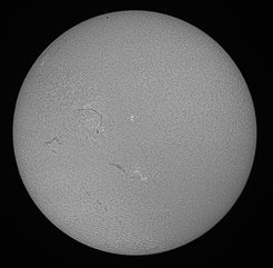 Black&white image of the transit of Mercury on 9 May 2016 as seen in H alpha. Mercury is visible as a small black dot near the upper rim of the Sun.