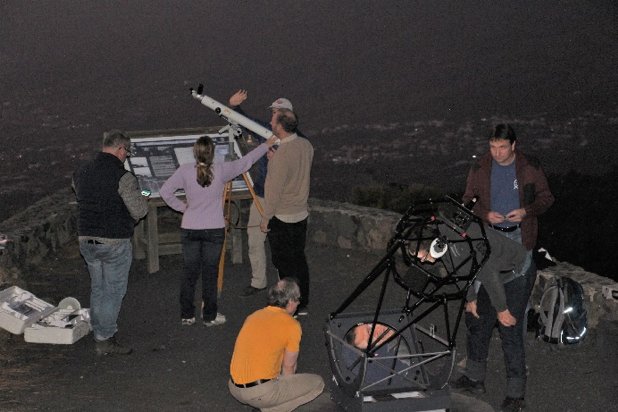Beobachtungsabend am (touristischen) astronomischen Beobachtungs-punkt Llano del Jable in 1342 m Höhe mit Blick auf den Westküstenort Los Llanos auf La Palma. Die praktische Arbeit lief in Kleingruppen ab. Eine der im Bild ersichtlichen Gruppen bestimmte mit Hilfe eines Schul-fernrohrs und der Durchlaufzeitmethode den Winkeldurchmesser von Jupiter, die andere Gruppe im Bildfeld nutzte ein größeres Dobson-Teles-kop für das Kennenlernen des Sternenhimmels bei einem Mini-Massiermarathon.