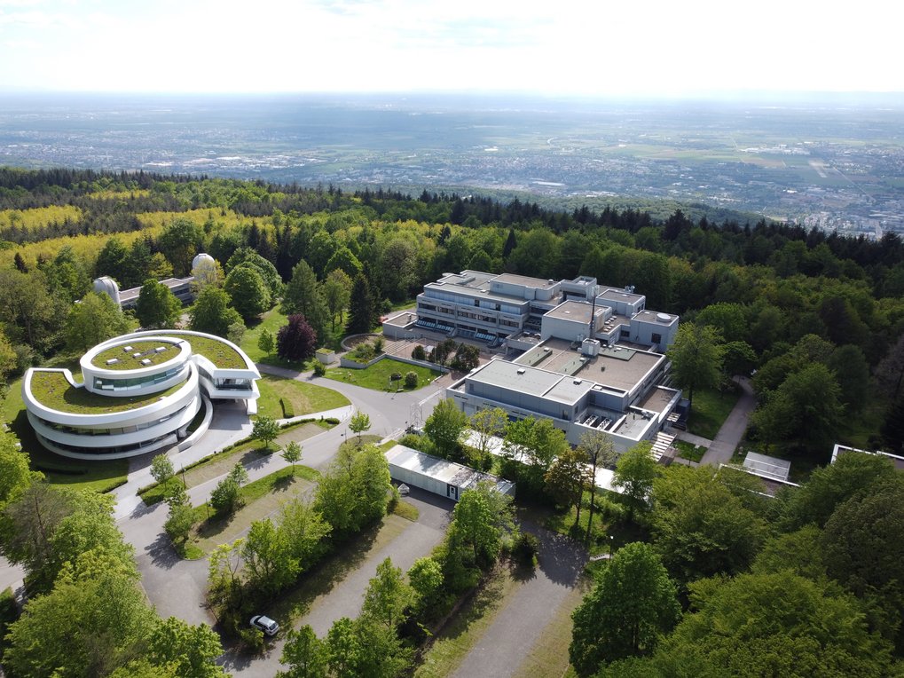 Luftaufnahme des MPIA-Campus bei blauem Himmel am 30. Mai 2021. Im Hintergrund Teile von Heidelberg.