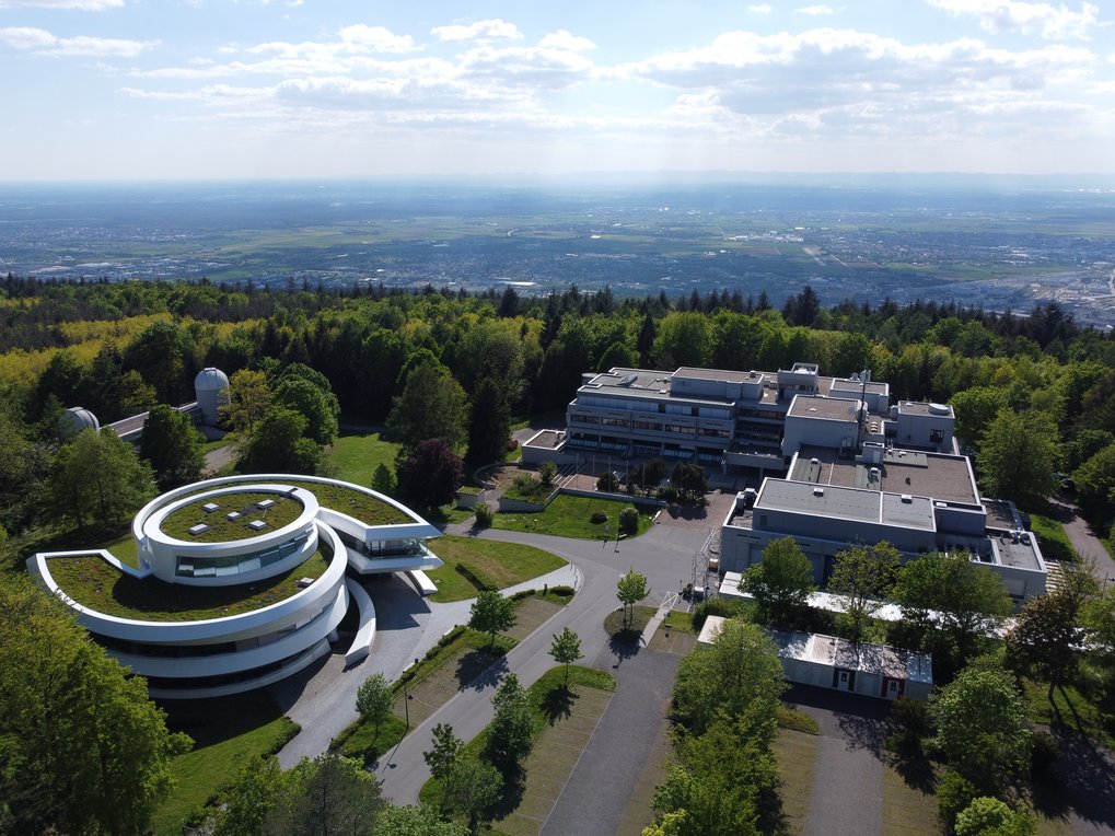 Luftaufnahme des MPIA-Campus bei blauem Himmel am 30. Mai 2021. Im Hintergrund Teile von Heidelberg.