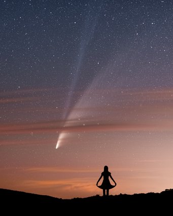 Hallo Komet, wollen wir tanzen?Dritter Platz des OAE-Astrofoto-Wettbewerbs des IAU OAE 2021 – Kategorie: Kometen. Ein Komet mit Gas- und Staubschweif über dem Horizont mit rötlich angeleuchteten Wolkenstreifen. Davor die Silhouette einer Frau, die ein Kleid trägt und den Rock mit den händen außen festhält