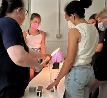 Abbildung 1: Eine Leuchtstoffröhre leuchtet wenn sie in die Nähe einer Plasmakugel kommt. Abbildung 1: Eine Leuchtstoffröhre leuchtet wenn sie in die Nähe einer Plasmakugel kommt.