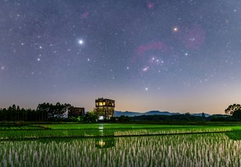 Watchtower and Paddy Fields Under the Starry Sky. Winner in the 2022 IAU OAE Astrophotography Contest in the category “Still images of celestial patterns” Over a watery field, Orion is shaped like a bow-tie turned 45 degrees. The bright star Sirius is in the image's left half