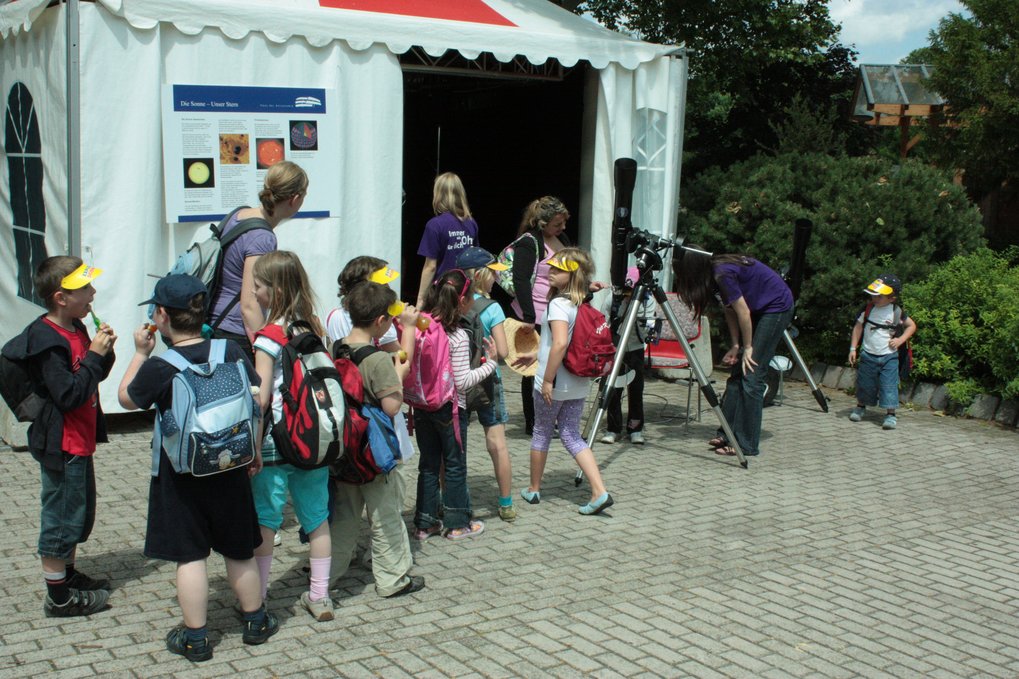 HdA-Mitarbeiterin Dr. Carolin Liefke zeigt Grundschulkindern an einem Teleskop mit Projektionseinrichtung ein Livebild der Sonne. Das Teleskop steht vor dem HdA-Stand auf der Explore Science 2010 – naturwissenschaftliche Erlebnistage der Klaus Tschira Stiftung im Luisenpark in Mannheim. Bild: HdA/M. Pössel